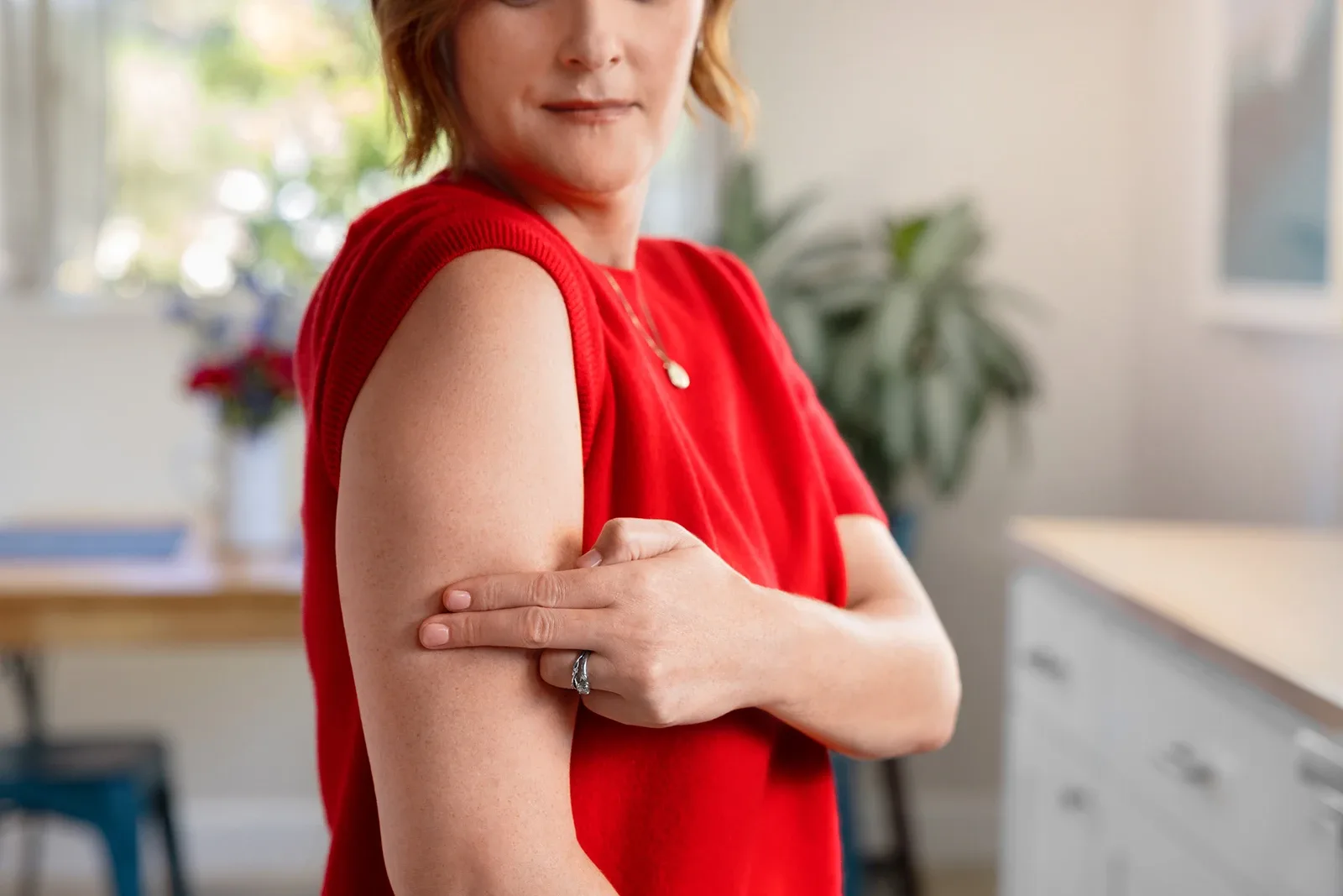 A woman pointing to her upper arm area