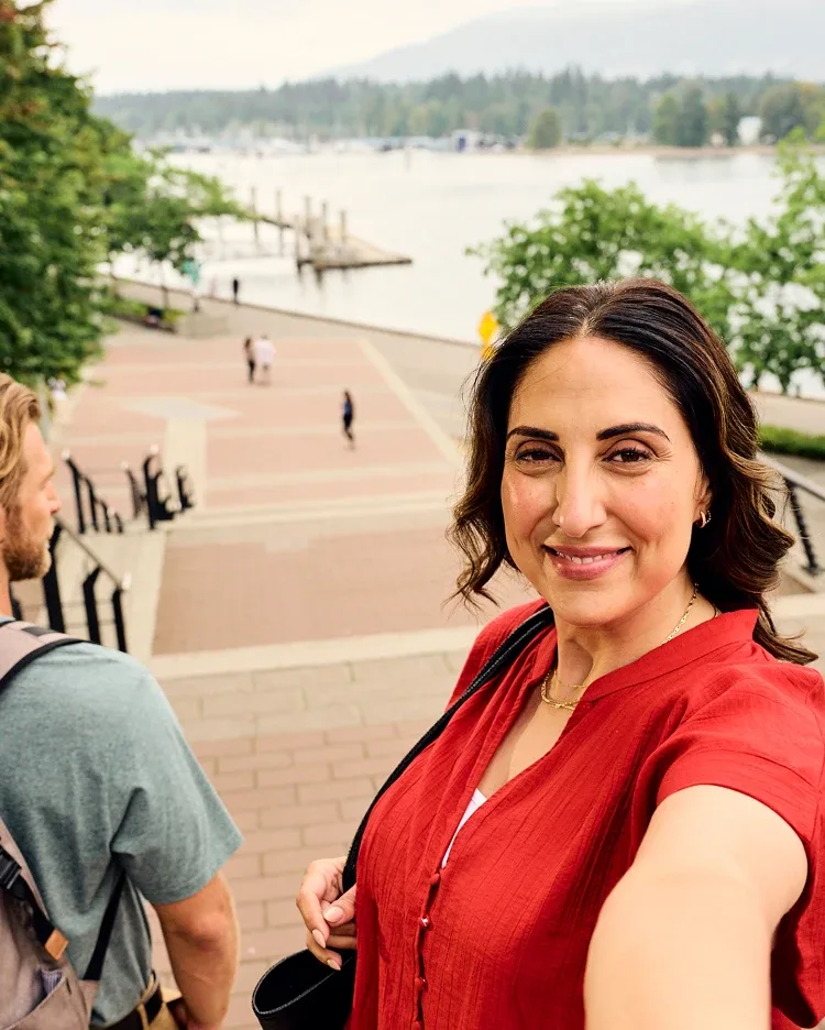 A woman taking a selfie at the top of the stairs outdoors